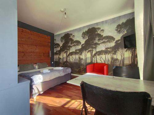 a bedroom with a bed and a table and a painting at Studio cosy centre historique Saint-Michel in Bordeaux