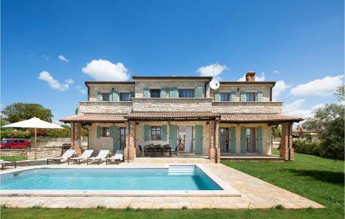 une grande maison avec une piscine devant dans l'établissement Villa Flower, à Sveti Lovreč Pazenatički