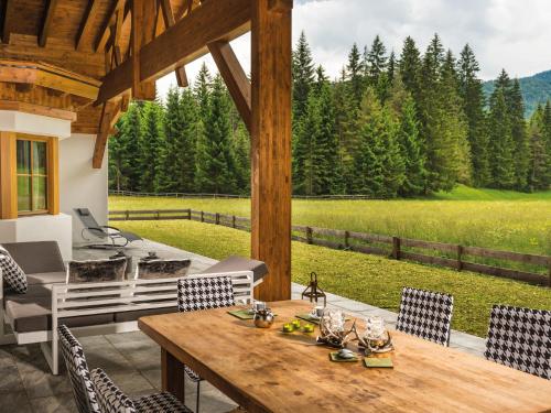 una mesa y sillas en un patio con vistas a un campo en Chalet Märchenblick, en Leutasch