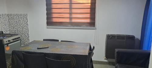 Una mesa y sillas en una cocina con ventana. en Hospedaje Don Hilario, en Gobernador Gregores