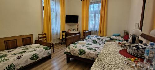 a room with two beds and a table with a tv at Kasztelania Pod Lipami in Zakroczym