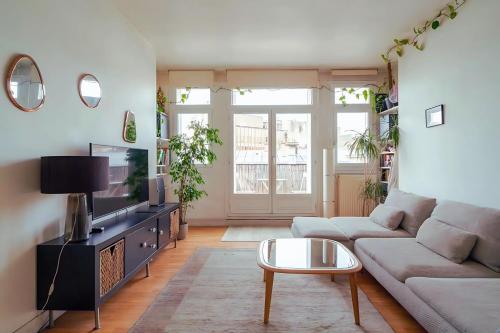 un salon avec un canapé et une télévision dans l'établissement 2 pièces proche Palais des Congrès, à Paris