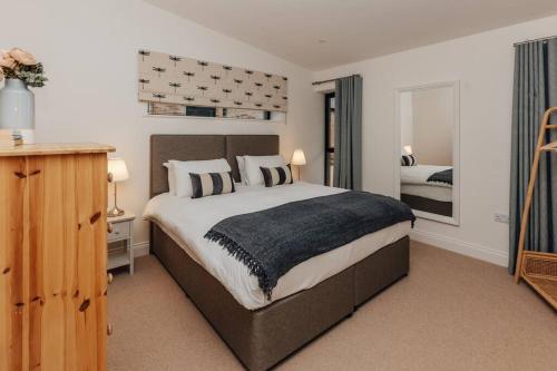 a bedroom with a large bed and a mirror at Cart Shed 2 in Nuneham Courtenay