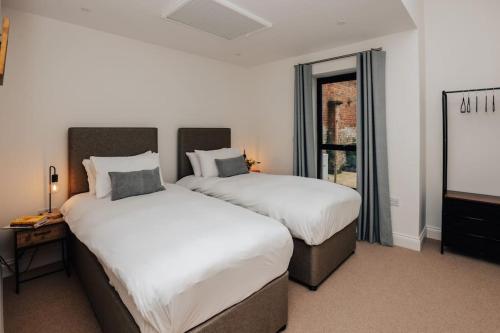 a bedroom with two beds and a television in it at Cart Shed 2 in Nuneham Courtenay