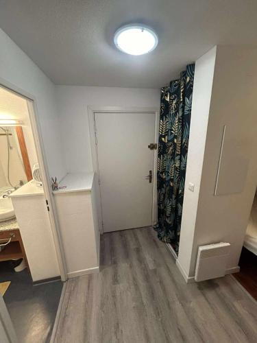 Cette chambre comprend une salle de bains pourvue d'un lavabo et d'une porte. dans l'établissement Appartement Station Ax 3 domaines, à Ax-les-Thermes