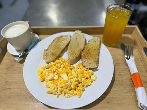 a plate of eggs and toast and a glass of orange juice at Hotel Boutique Chateau de la Mar in Juan de Acosta