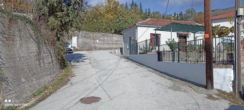 an empty street with a house and a building at Rose Garden Cottage in Katochori