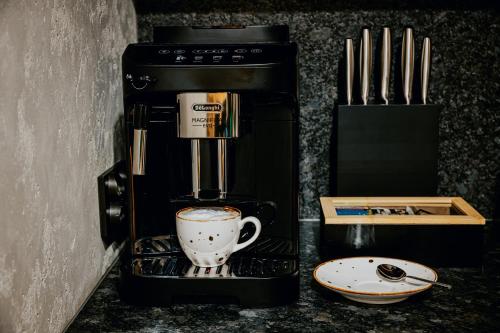 a coffee maker with a cup on a counter at Czorsztyn Prestige Osada in Czorsztyn