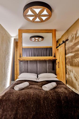 a bedroom with a large bed with two pillows on it at Czorsztyn Prestige Osada in Czorsztyn