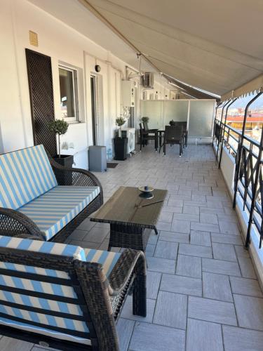 un patio con sofás y mesas en un balcón en 19 Αri, en Tríkala