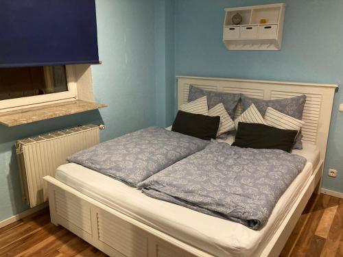 a bed in a room with a blue wall at 2 BR beautyful vacation home / Ferienhaus Brunsberg in Buchholz in der Nordheide