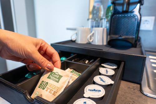 a person is reaching for a box of food at LiRo Hotel-Pension Haus Andrea in Niederkrüchten