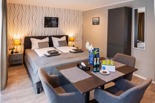 a bedroom with a bed and a table with chairs at LiRo Hotel-Pension Haus Andrea in Niederkrüchten