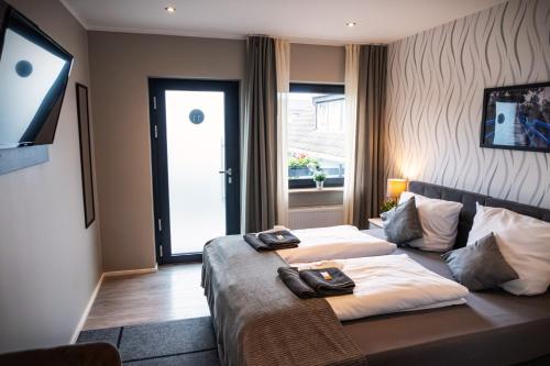 a hotel room with two beds and a television at LiRo Hotel-Pension Haus Andrea in Niederkrüchten