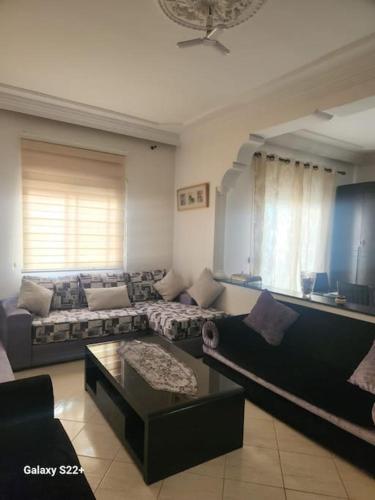 a living room with a couch and a coffee table at Naj'Appart TEMARA WIFAK CALME SITUÉ PRÉS DE LA GARE FERROVIAIRE 4 MIN A PIED in Temara