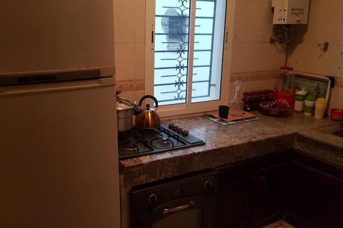 a kitchen with a stove with a tea kettle on it at Naj'Appart TEMARA WIFAK CALME SITUÉ PRÉS DE LA GARE FERROVIAIRE 4 MIN A PIED in Temara