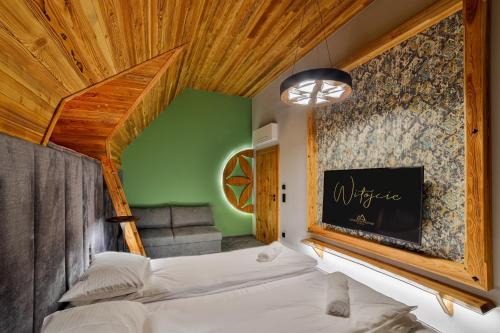 a bedroom with a bed and a green wall at Czorsztyn Prestige Osada in Czorsztyn