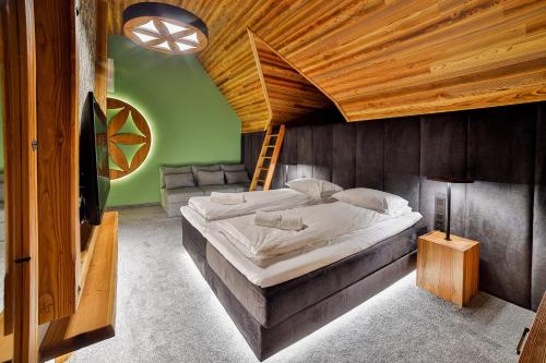 a bedroom with a large bed with a wooden ceiling at Czorsztyn Prestige Osada in Czorsztyn