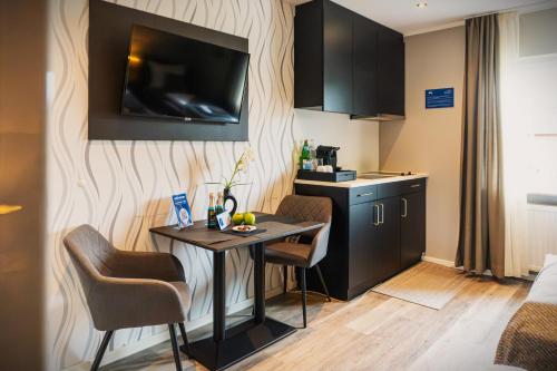 a small room with a table and a kitchen at LiRo Hotel-Pension Haus Andrea in Niederkrüchten