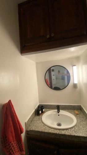 a bathroom with a sink and a mirror at Naj'Appart TEMARA WIFAK CALME SITUÉ PRÉS DE LA GARE FERROVIAIRE 4 MIN A PIED in Temara
