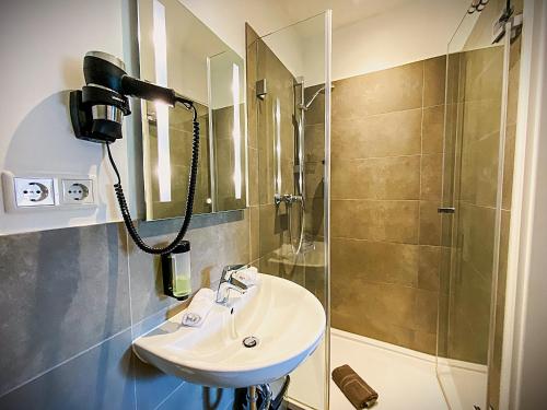 a bathroom with a sink and a shower at LiRo Hotel-Pension Haus Andrea in Niederkrüchten