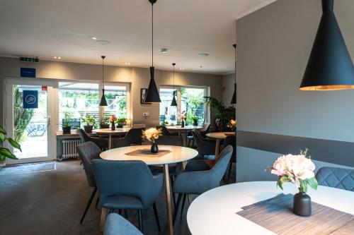 a dining room with tables and chairs and a restaurant at LiRo Hotel-Pension Haus Andrea in Niederkrüchten