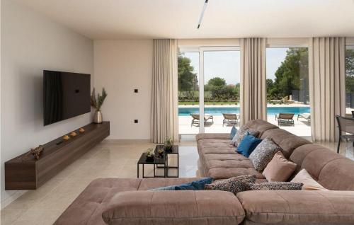 ein Wohnzimmer mit einem großen Sofa und einem Fernseher in der Unterkunft Villa Gloria in Frata