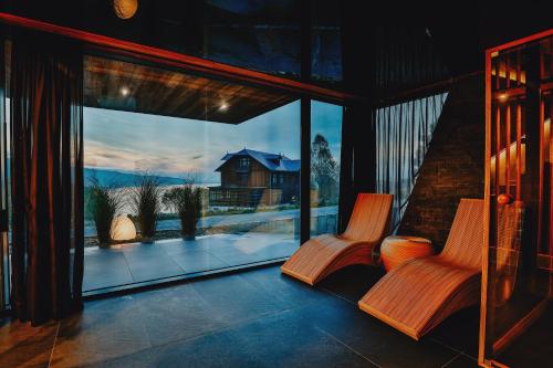 two chairs on a porch with a view of a house at Czorsztyn Prestige Osada in Czorsztyn