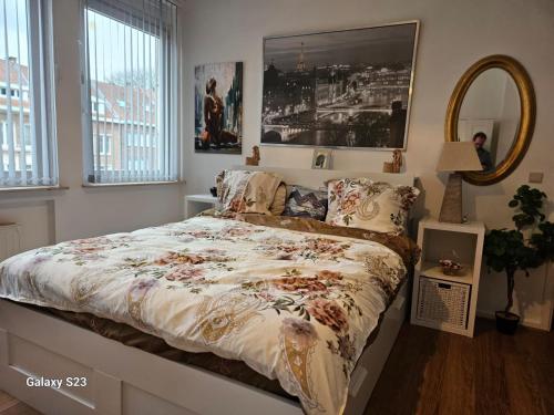 a bedroom with a bed with a floral comforter and a mirror at Friend House in Brussels