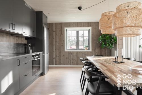 a kitchen with a wooden table and black cabinets at The Black Deer Lodge in Tällberg