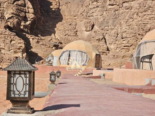 a row of domes in a desert with a mountain at RUM WORLD BUBBLE lUXURY CAMP in Wadi Rum