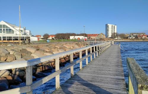 a wooden dock in the water next to a building at 3 Bedroom Beautiful Home In Höganäs in Höganäs