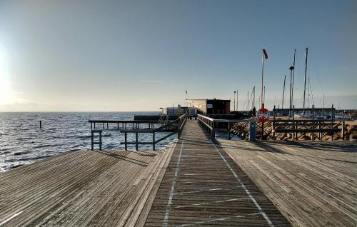 a wooden pier next to the water with boats at 3 Bedroom Beautiful Home In Höganäs in Höganäs