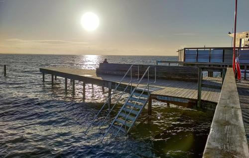 a wooden pier with a ladder on the water at 3 Bedroom Beautiful Home In Höganäs in Höganäs