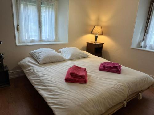 two towels on a white bed in a bedroom at Gîte de Pipala in Mittlach