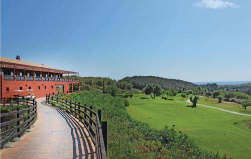 a building with a fence and a green yard at Casares Del Sol in Casares