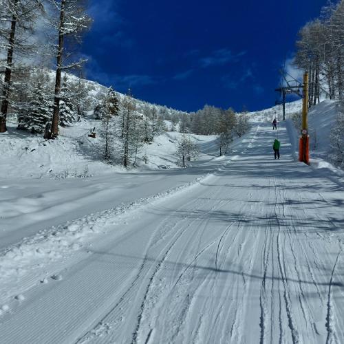 a person is skiing down a snow covered road at Le Studio du Queyras avec vue sur la montagne in Abriès