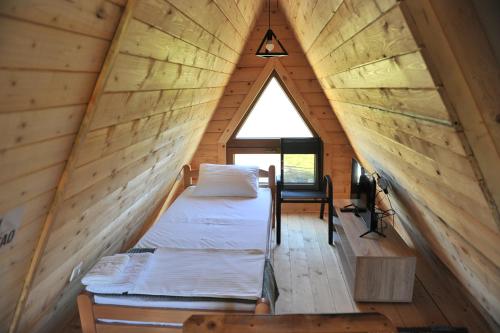 a bed in a room with a large window at Androv kutak in Andrići