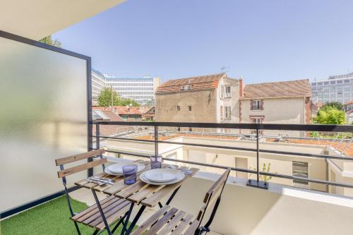 d'un balcon sur le toit avec une table et des chaises. dans l'établissement Le Grey - Paris - Gare du Nord, à Arcueil
