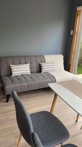 a living room with a couch and a table at Cabañas Entre Sauces in Coihaique