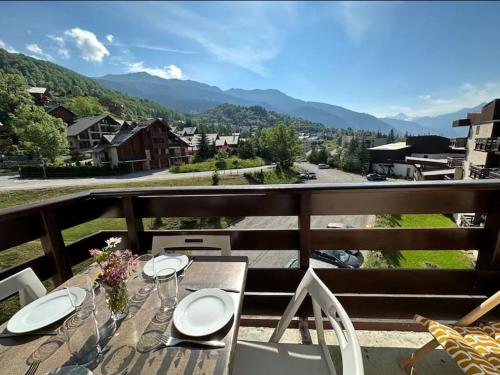 ein Tisch auf einem Balkon mit Blick auf die Berge in der Unterkunft Serre Chevalier Chantemerle Vue Montagne in Saint-Chaffrey