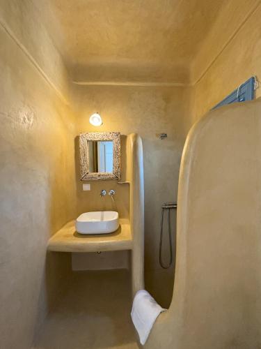 a bathroom with a sink and a mirror at Almyra Red Villa in Kithnos
