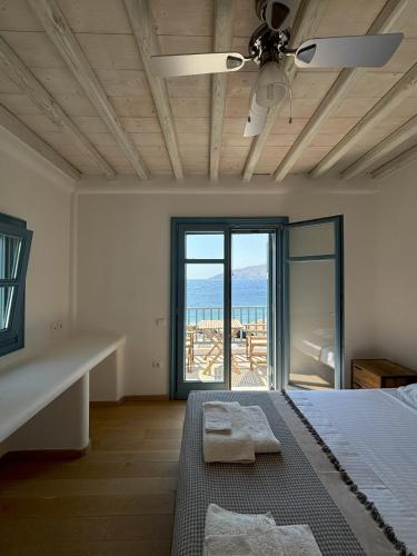 a bedroom with a bed and a view of the ocean at Almyra Red Villa in Kithnos