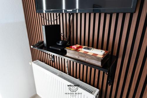 a room with a wall with a shelf with a television at Heaven Heart - Apartmani Tuzla in Tuzla