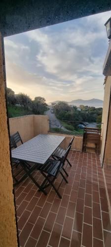 une table et des chaises sur un balcon avec vue sur une rivière dans l'établissement Appartement accès piscine collective Porticcio Corse du sud, à Porticcio