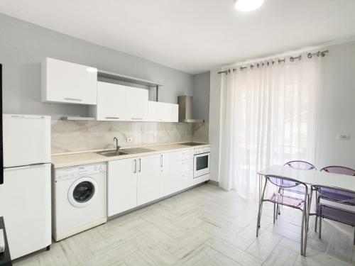 Una cocina con electrodomésticos blancos y una mesa con sillas. en TRn, en Golem