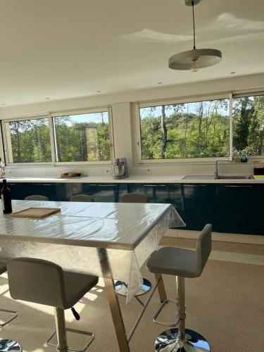 - une cuisine avec une grande table et des chaises en marbre dans l'établissement La maison de Charles, à Saint-Aubin-de-Branne