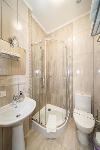 a bathroom with a shower and a toilet and a sink at L.O.Y Family Hotel in Dnipro