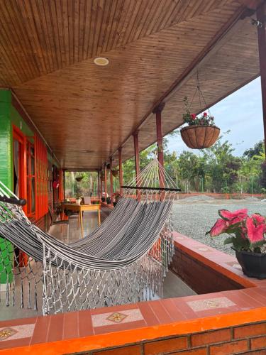 a hammock on a porch of a building at Finca La Gaviota in Montenegro