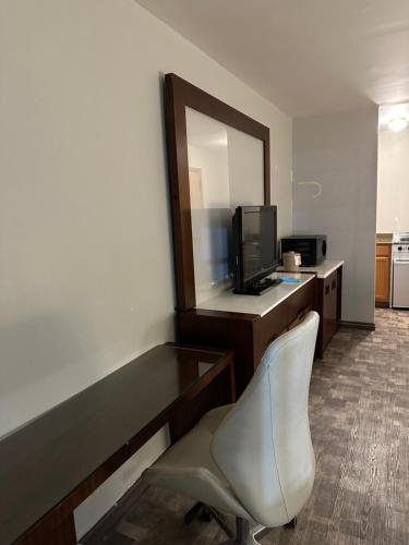 a hotel room with a desk with a mirror and a chair at The Boston Inn in Westminster
